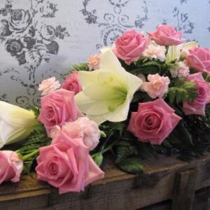 Surukimppu lilja ja vaaaleanpunaiset ruusut